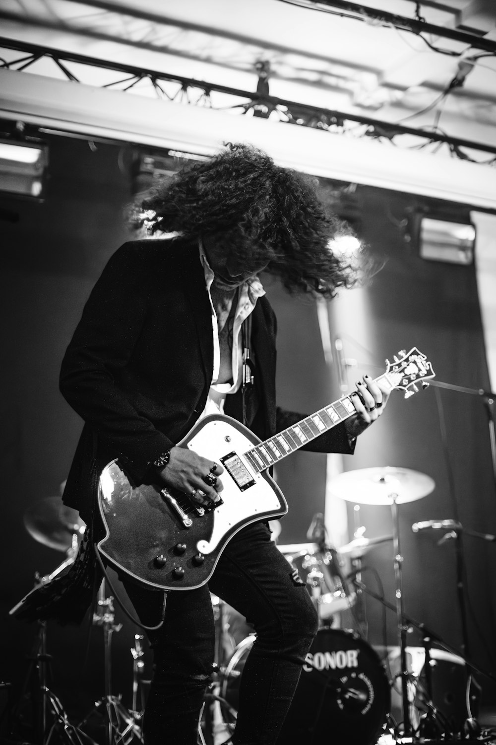 a black and white photo of a man playing a guitar
