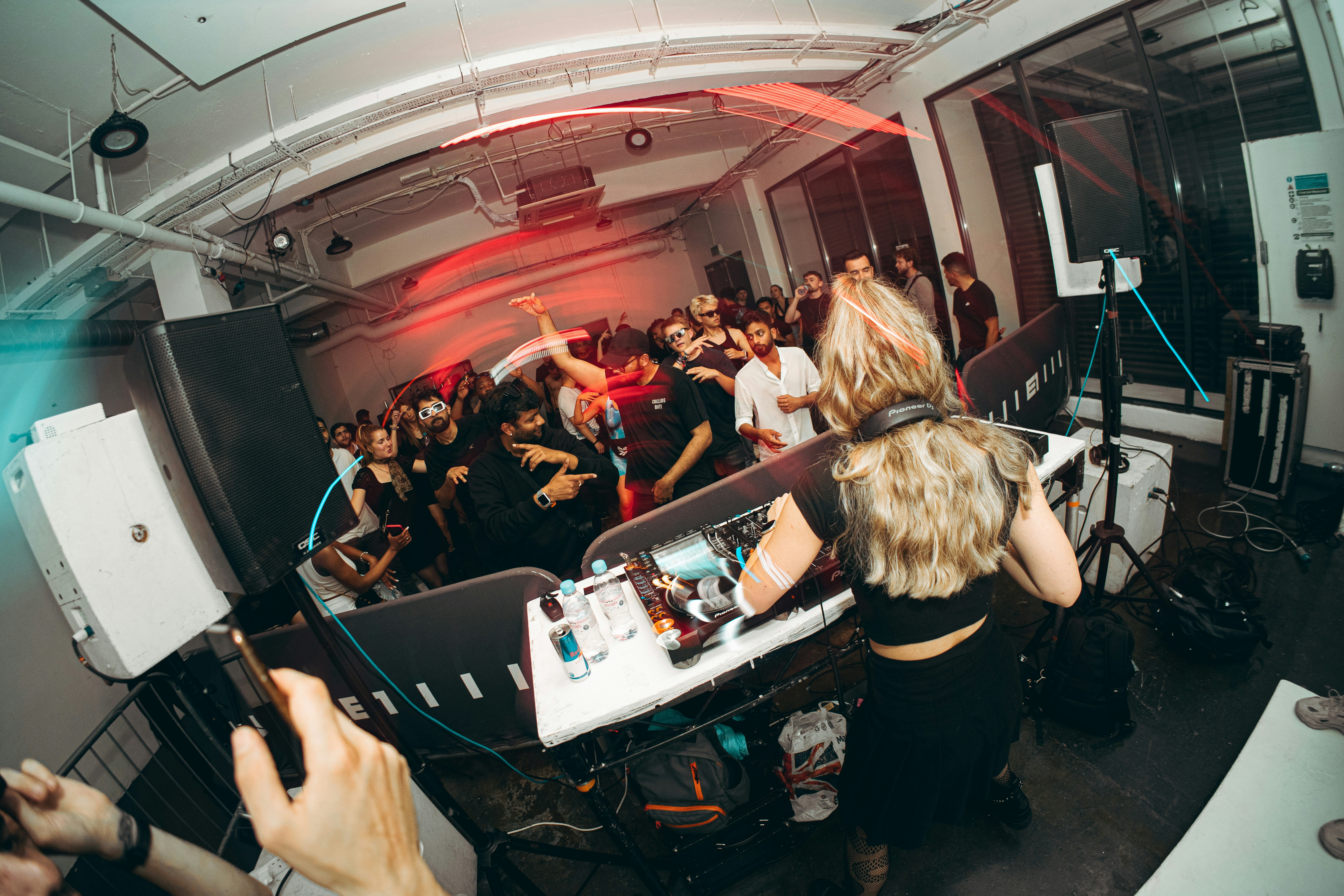 a group of people in a room with dj equipment, 