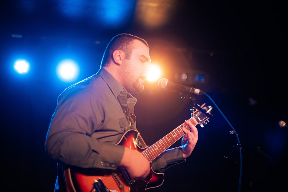 a man that is playing a guitar on a stage