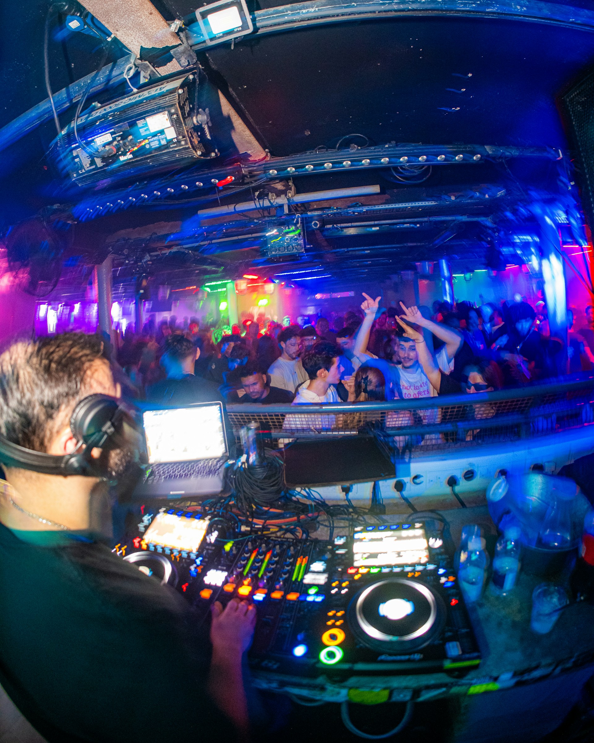 a dj mixing in front of a crowd of people