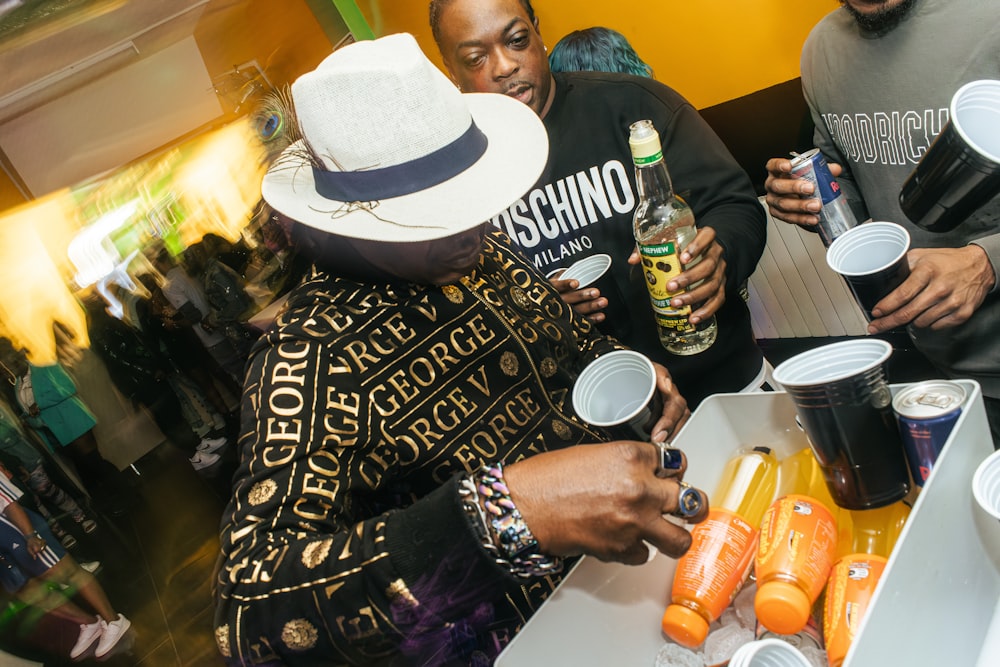 a group of people standing around a table with drinks