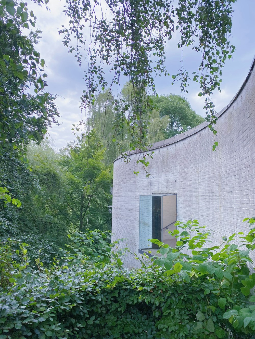 a building that is surrounded by trees and bushes