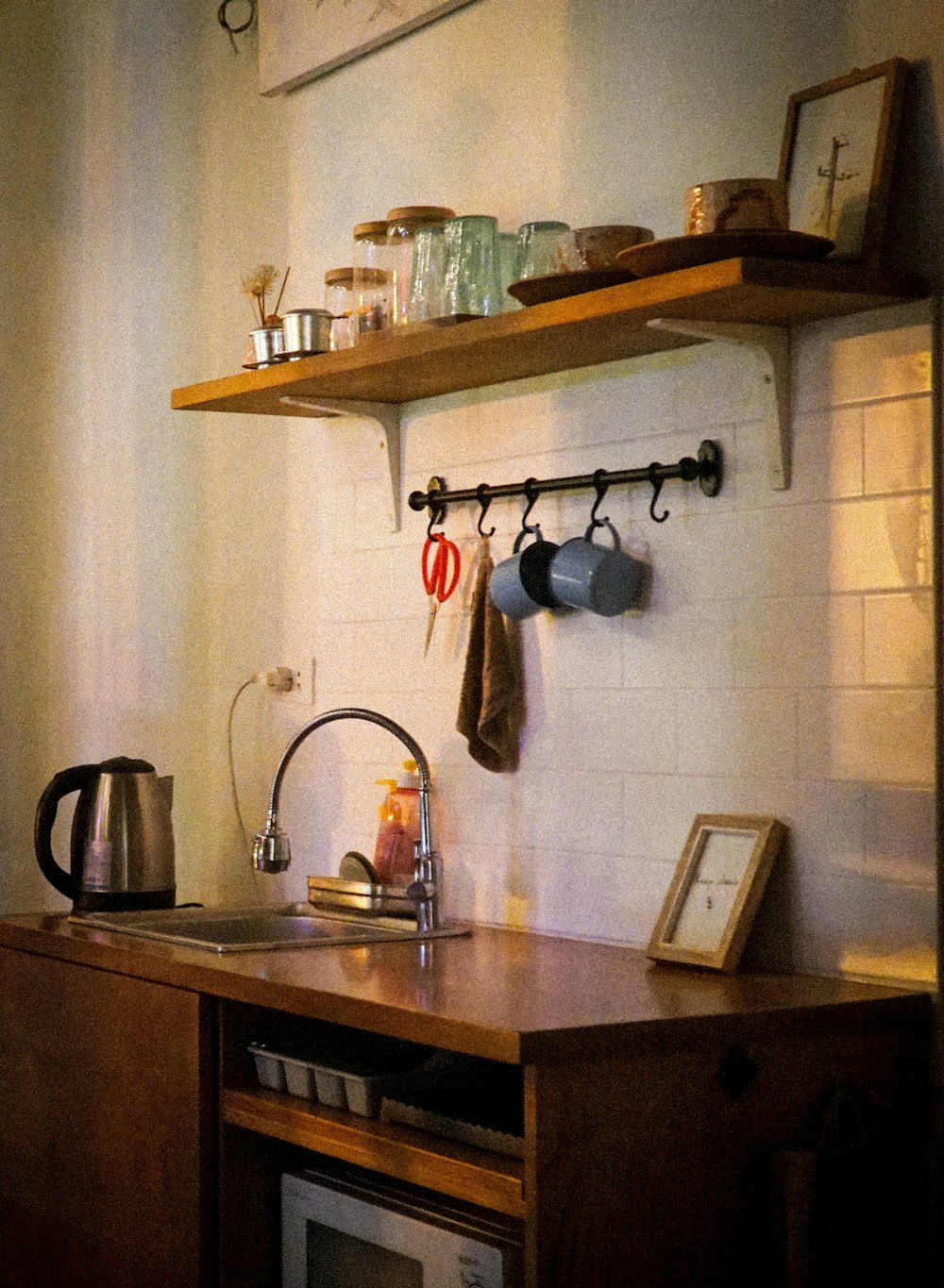 a kitchen with a microwave and a shelf with pots and pans