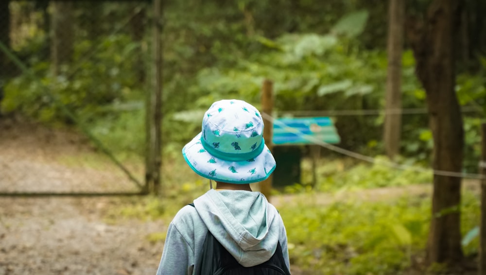 a person wearing a hat walking in the woods