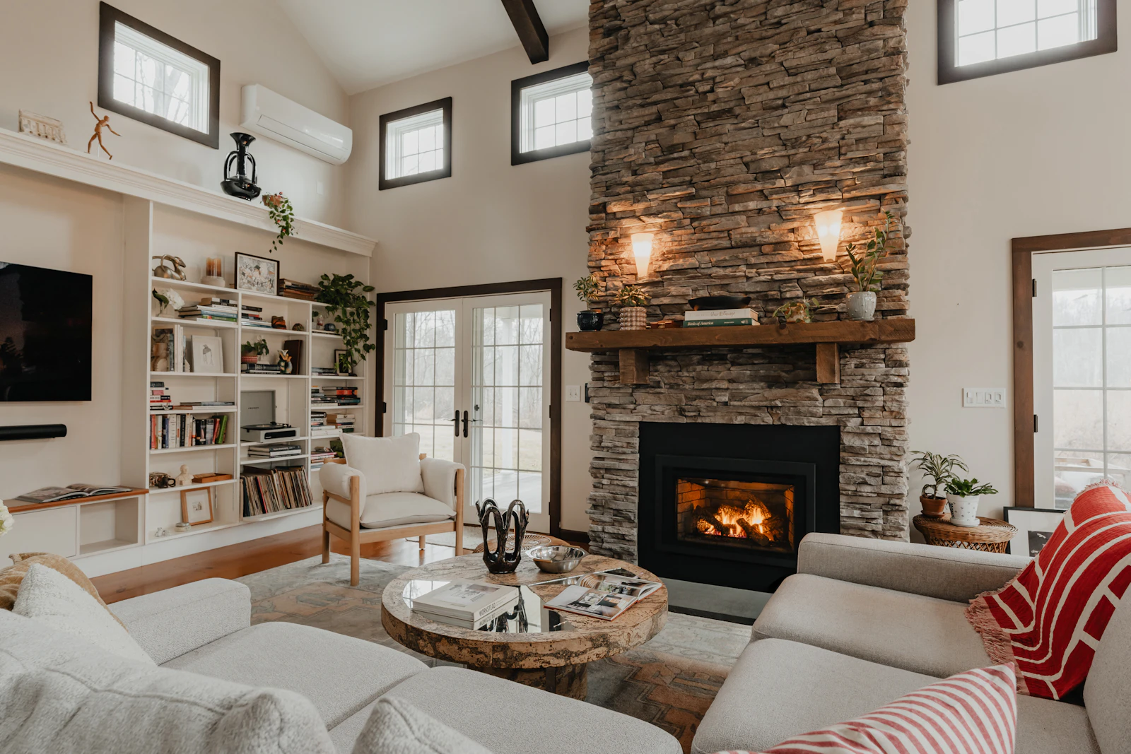 A bright living room warmed by a stone fireplace