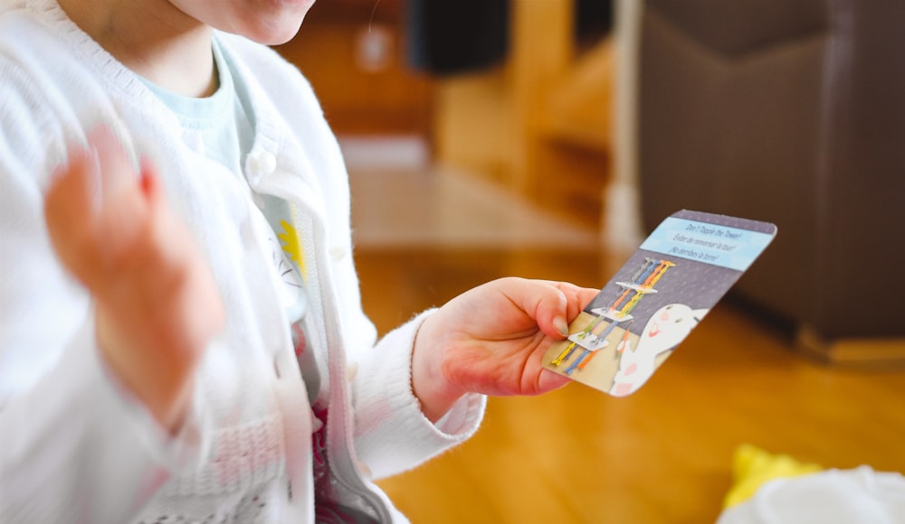 a woman is holding a card in her hand