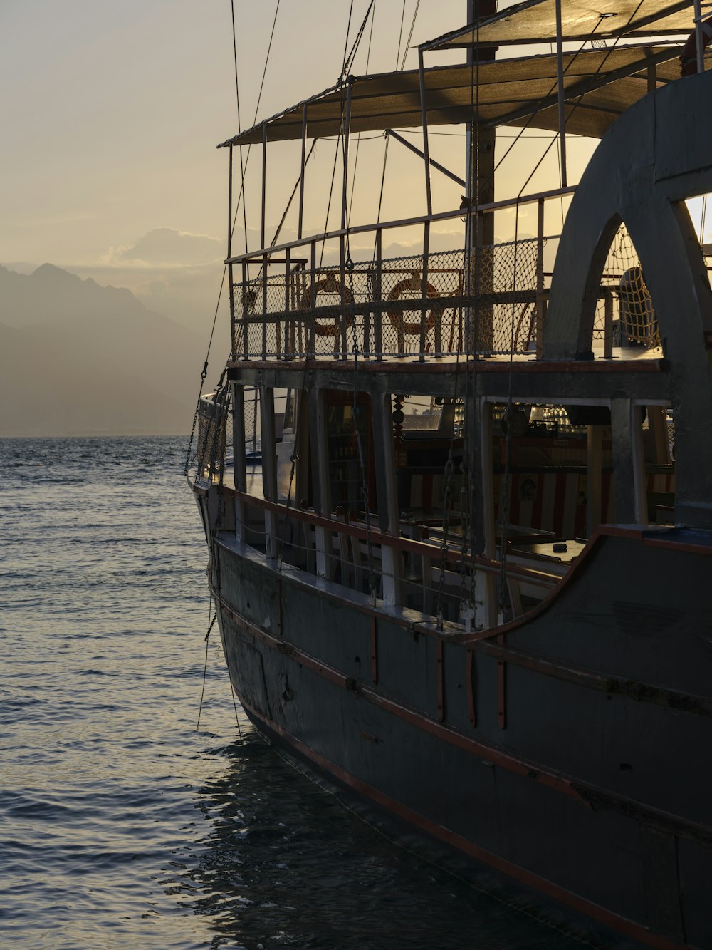 a large boat in the water with mountains in the background