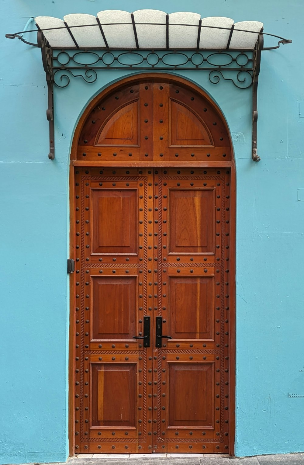 a blue building with a wooden door and a bench