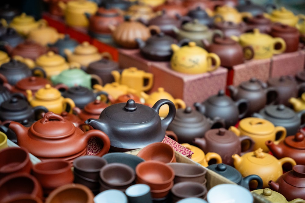 a table topped with lots of different colored teapots
