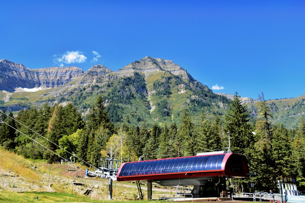 a red and black train on a track near a mountain