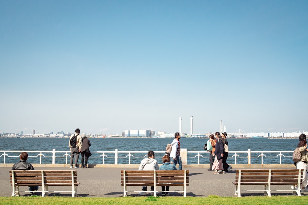 a group of people sitting on top of wooden benches