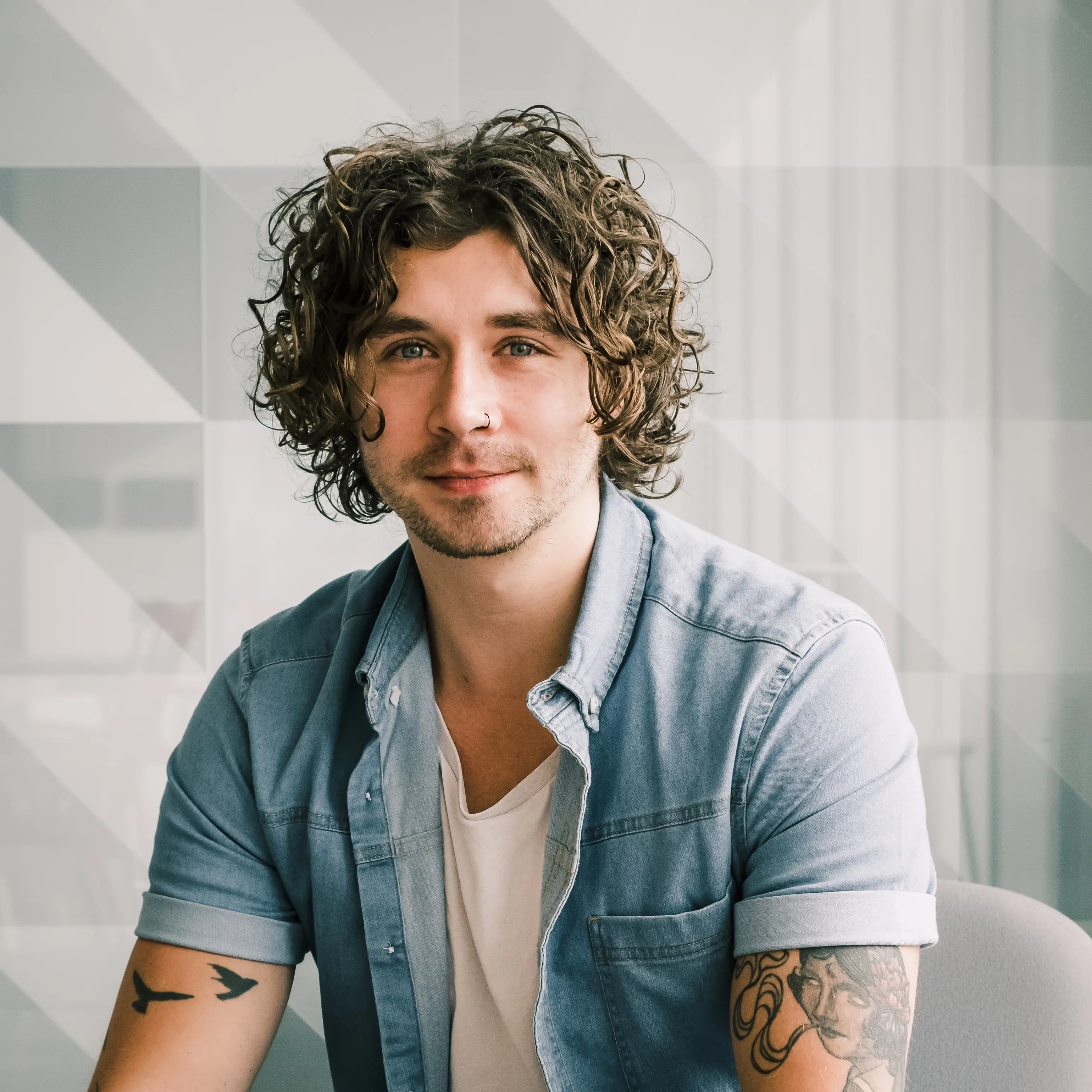 a man with long hair sitting at a desk