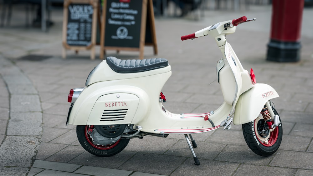 a white scooter parked on a brick sidewalk
