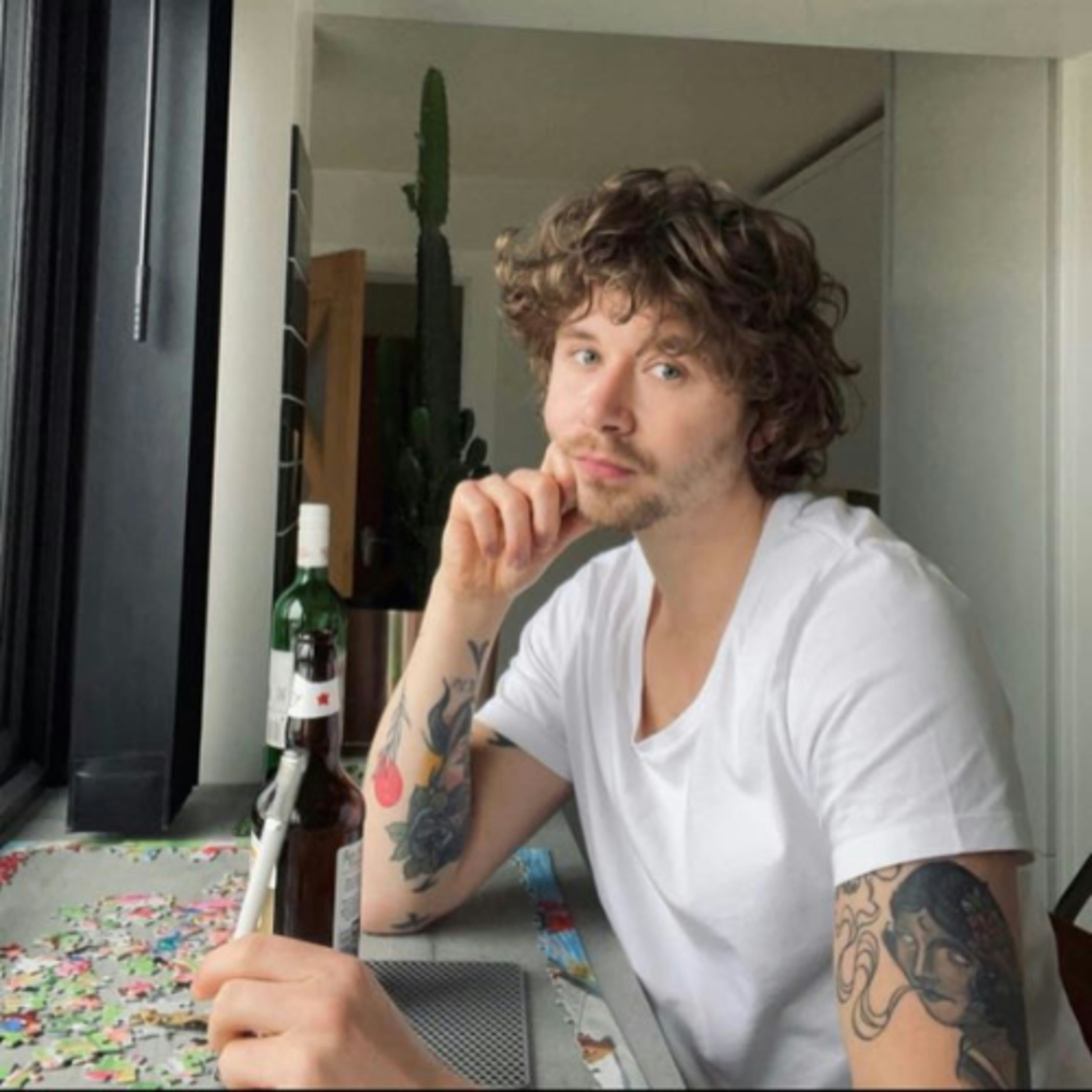 a man sitting at a table with a bottle of wine