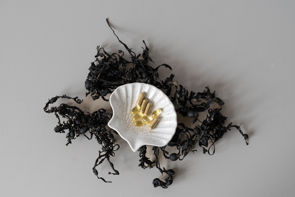 a white bowl filled with black tea next to a pile of black tea