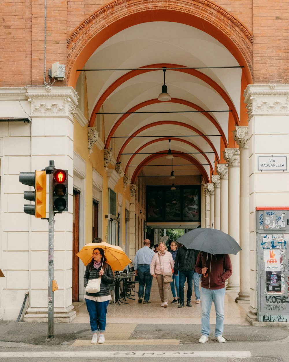 a group of people walking down a street holding umbrellas