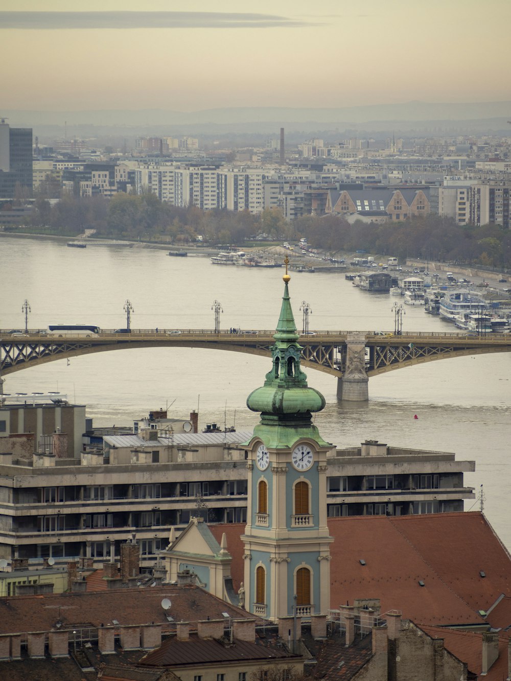 uma vista de uma cidade com uma ponte e uma torre do relógio