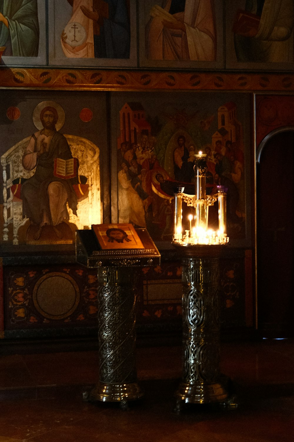 a lit candle sitting on top of a table in front of a painting