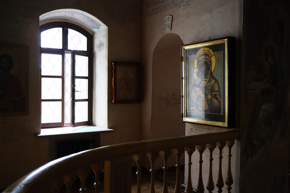 a staircase with a painting on the wall next to a window