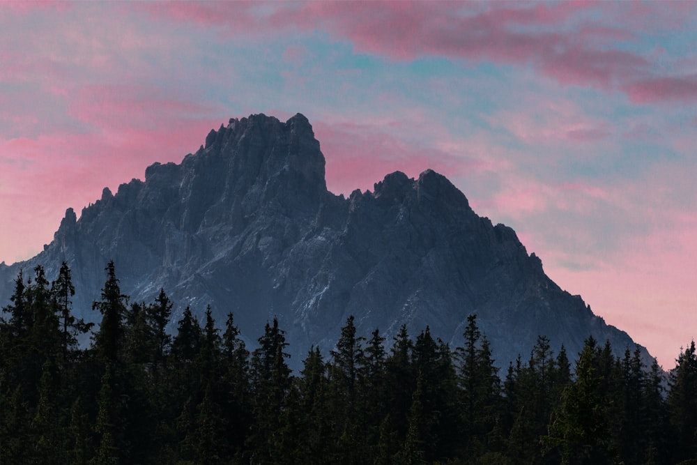 une montagne avec un ciel rose en arrière-plan