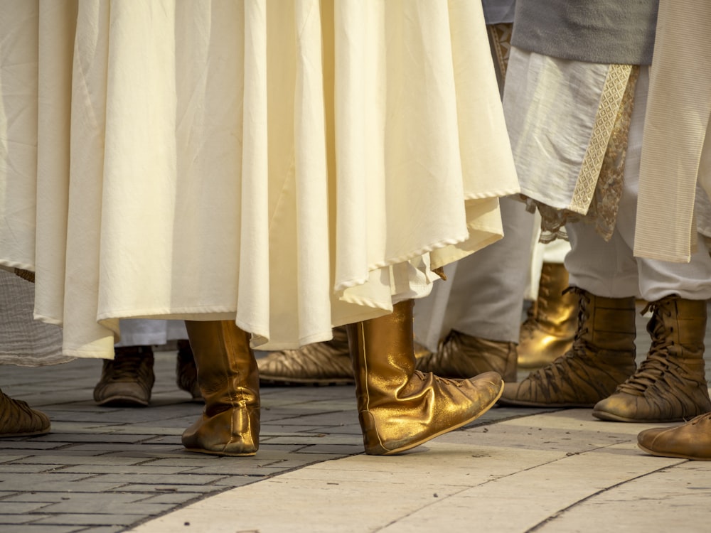 a group of people standing next to each other wearing gold shoes