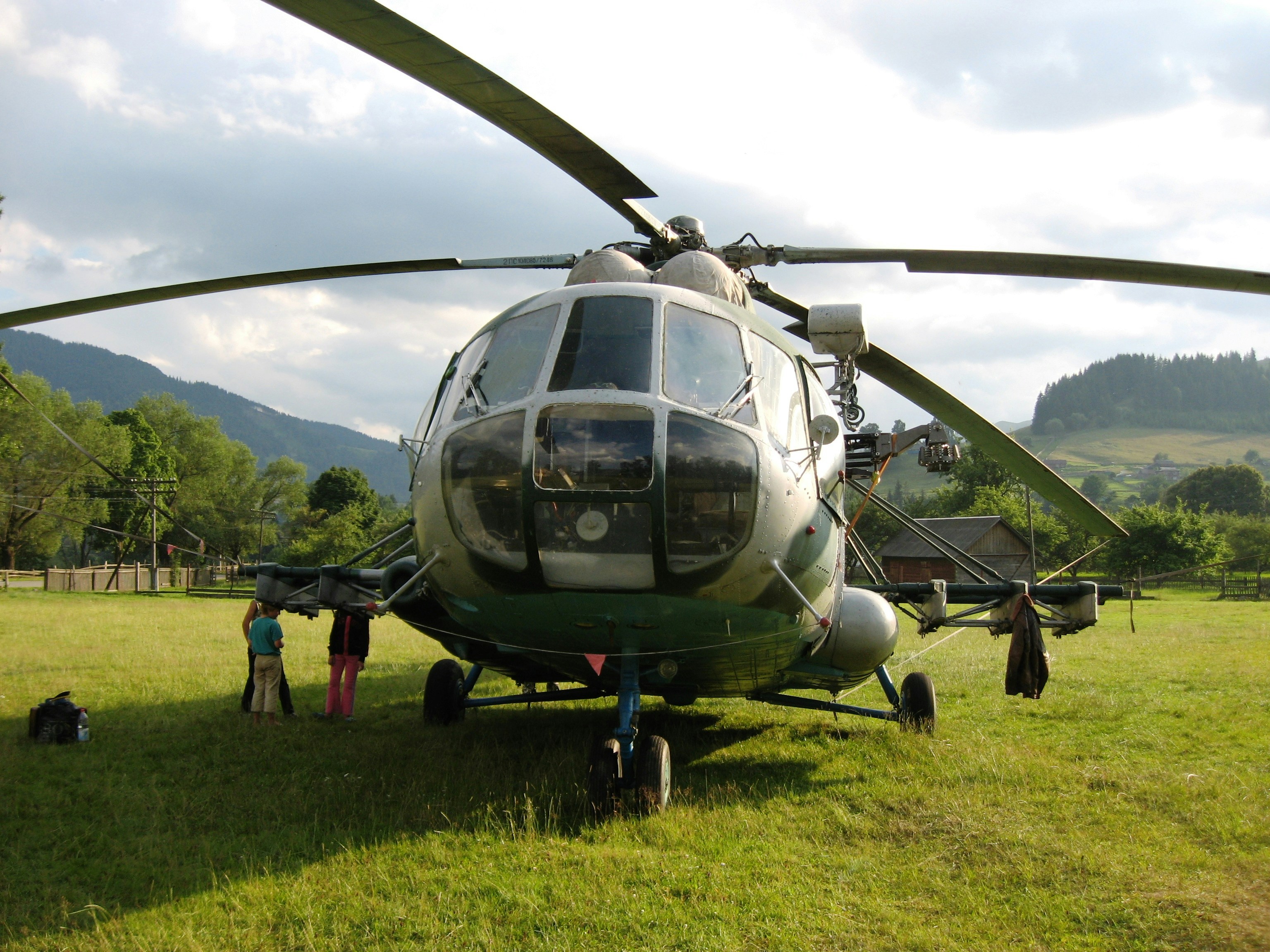 a helicopter sitting on top of a lush green field