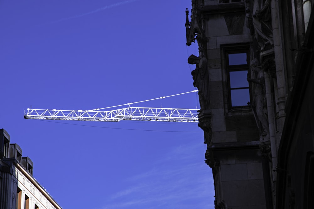 a white crane is in the air above a building