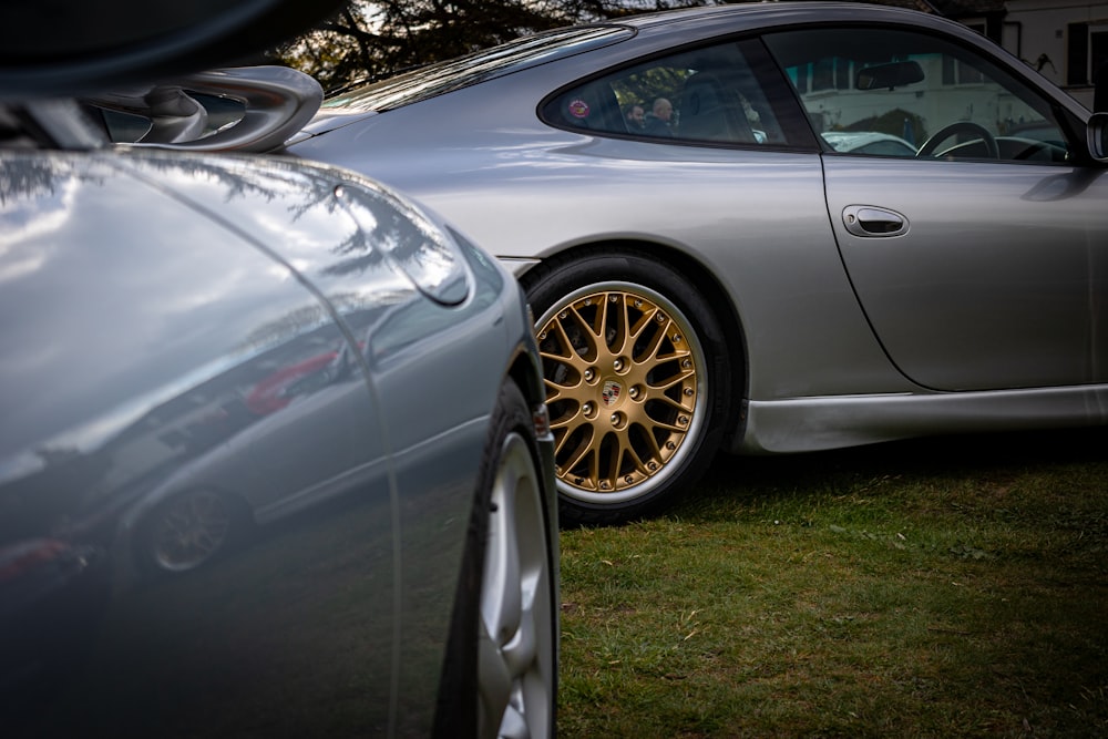 a silver sports car parked next to a silver sports car