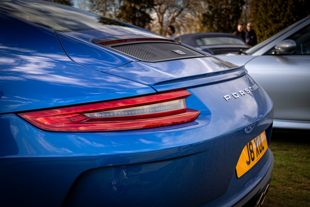 a blue sports car parked next to a silver car