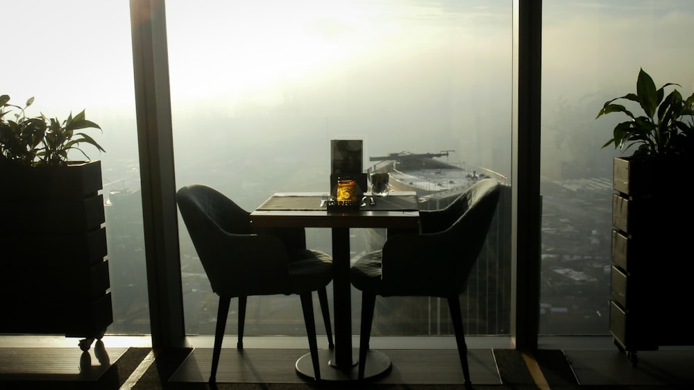 a table with two chairs and a bottle of wine