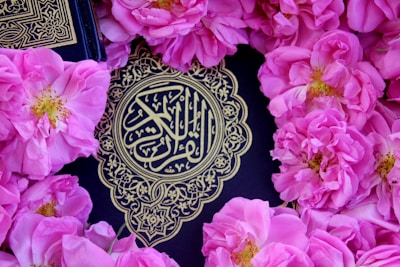 pink flowers surround the holy book of the koran
