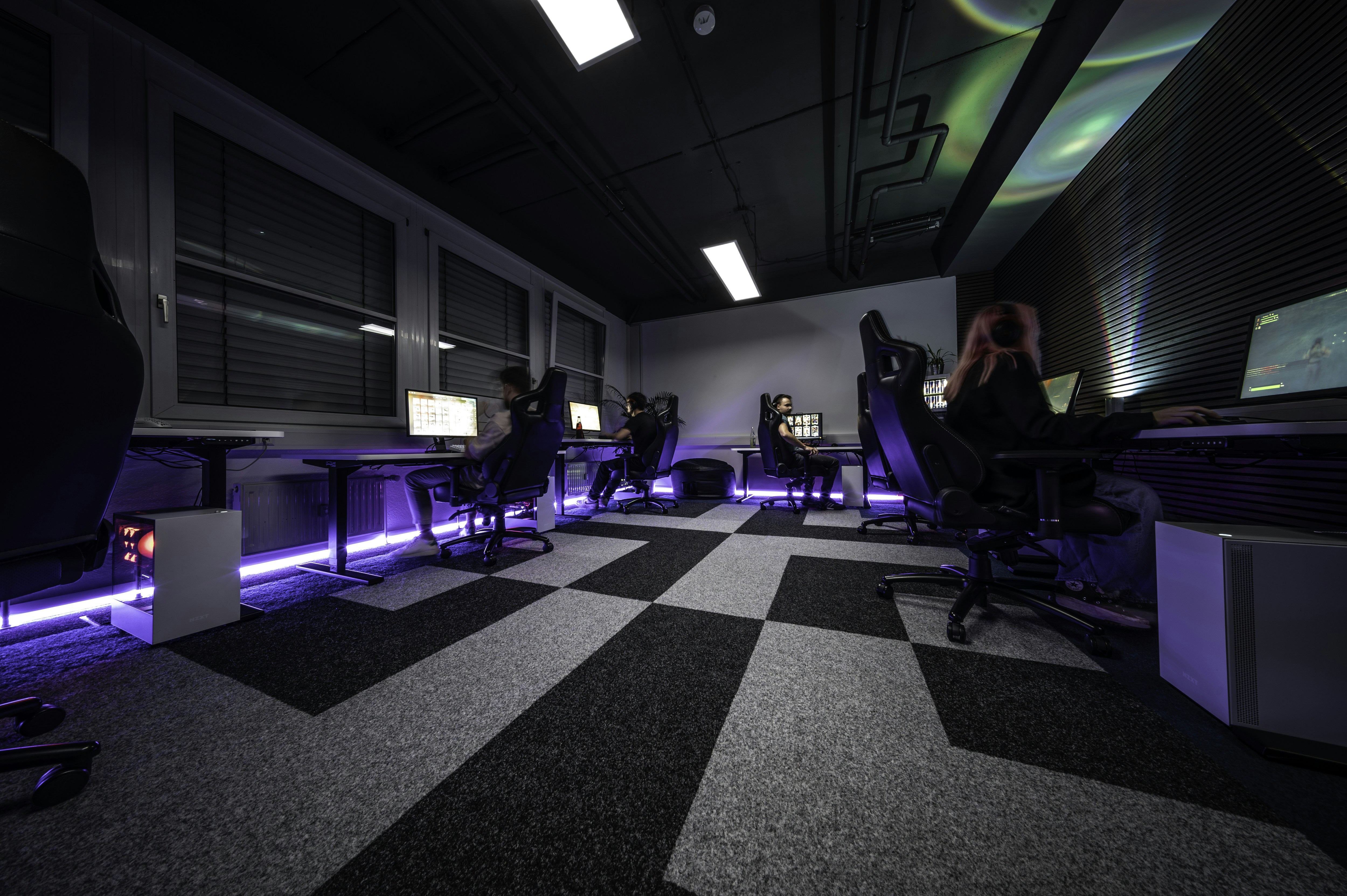 a group of people sitting at desks in a room, 