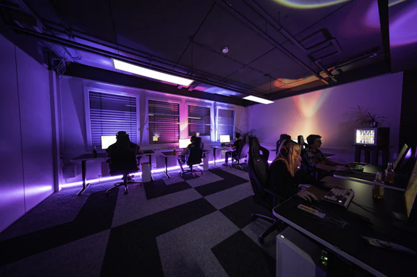 A group of people sitting around a computer desk