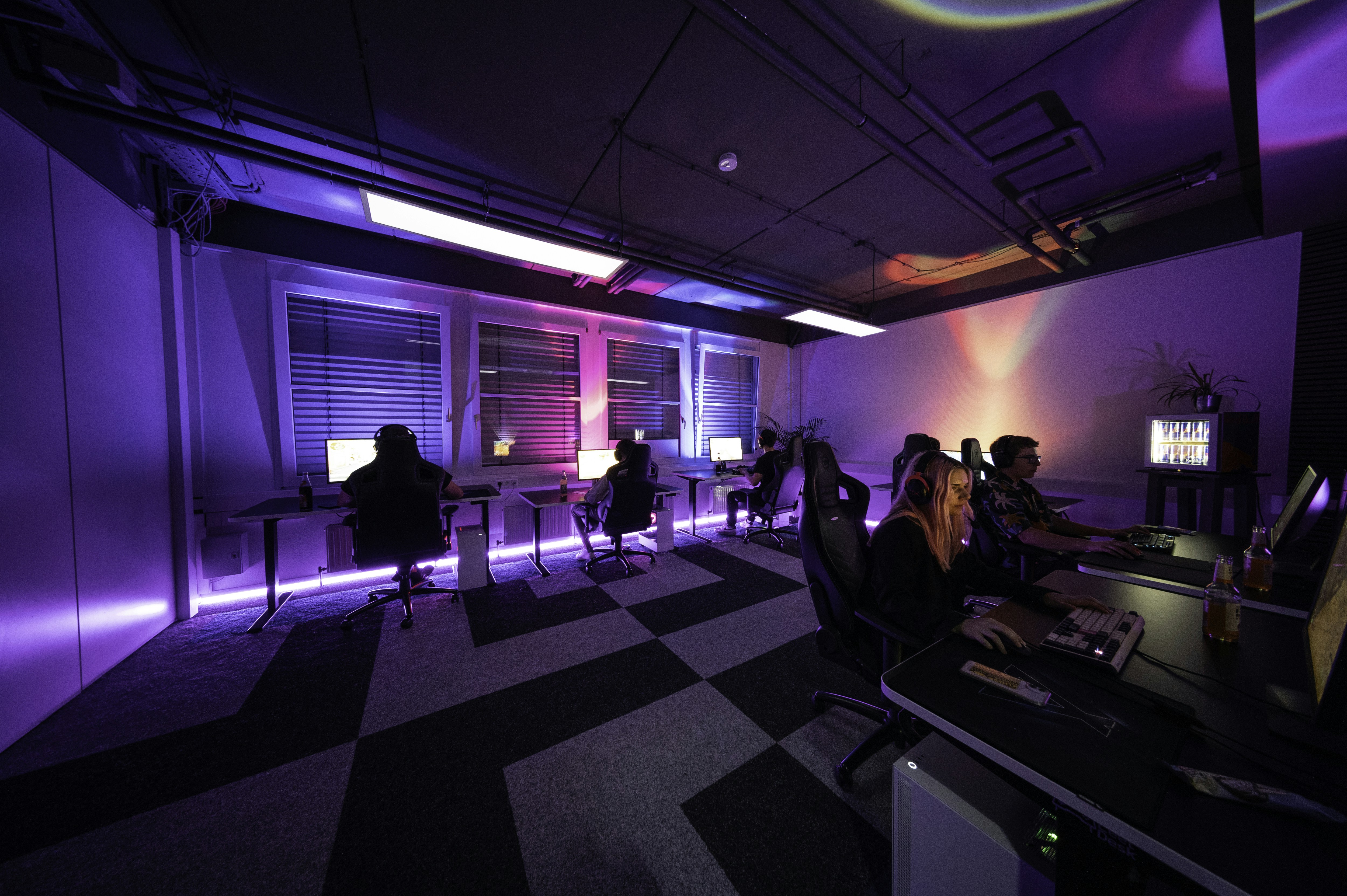a group of people sitting around a computer desk