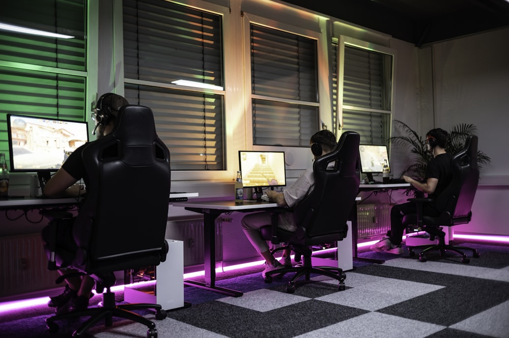 a group of people sitting at desks in front of monitors