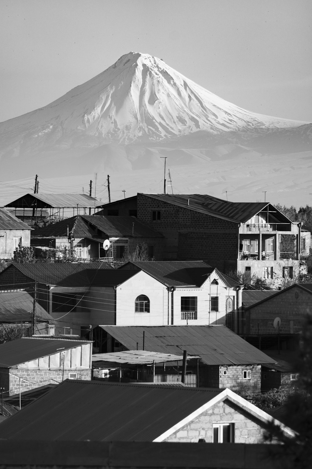 a black and white photo of a city with a mountain in the background
