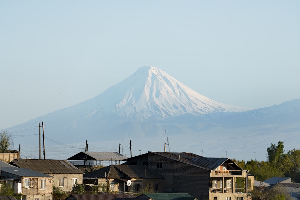 a snow covered mountain towering over a city