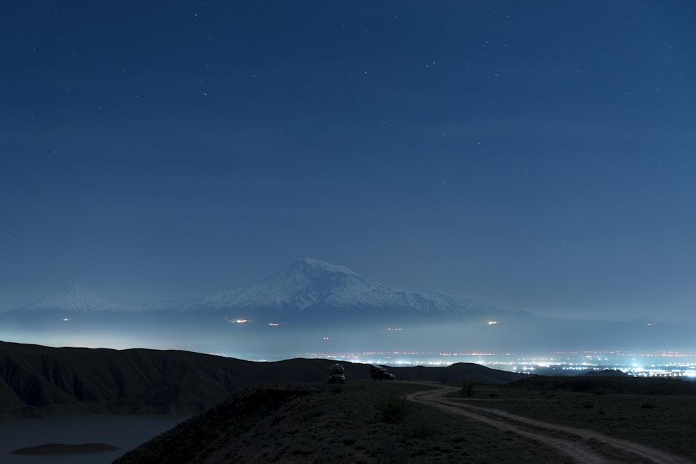 a dirt road with a mountain in the background