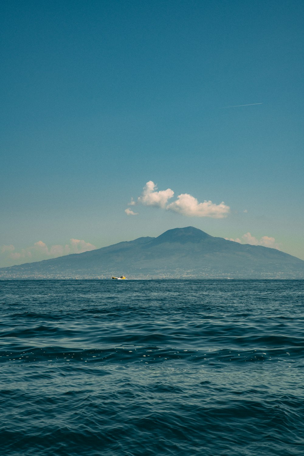 a large body of water with a mountain in the background