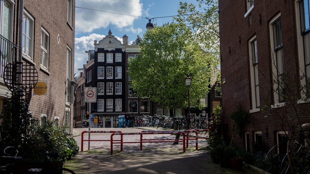 a narrow city street with a red gate