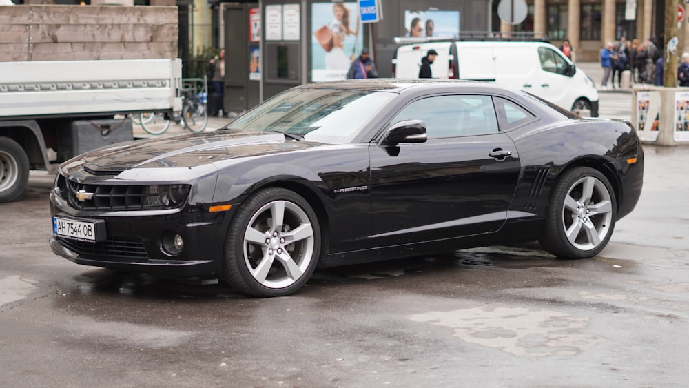 a black chevrolet camaro parked in a parking lot