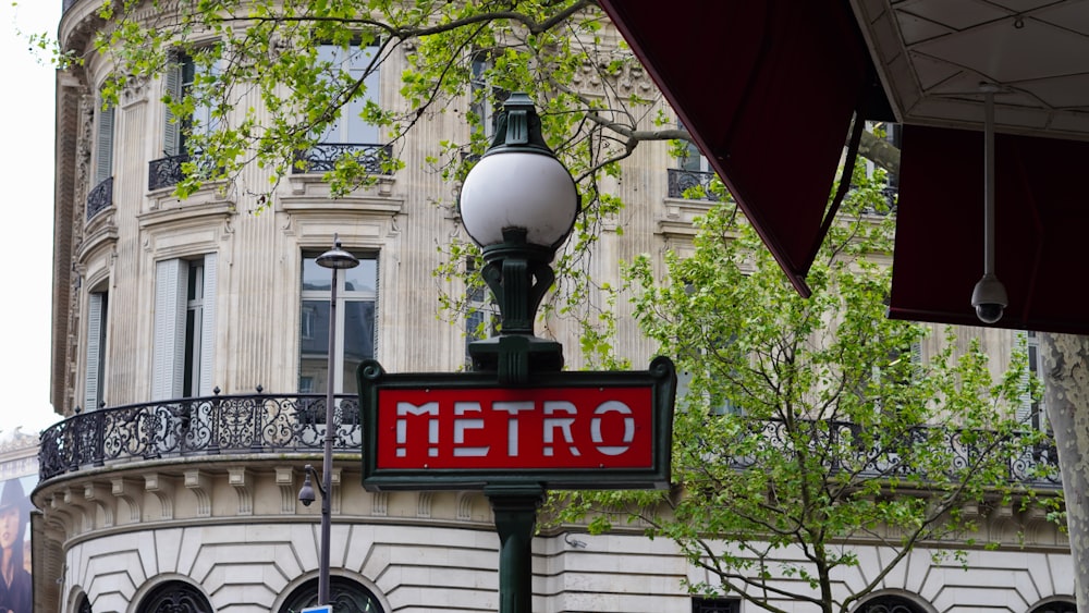 a metro sign on a lamp post in front of a building