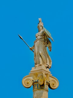 a statue of a woman holding a sword on top of a building
