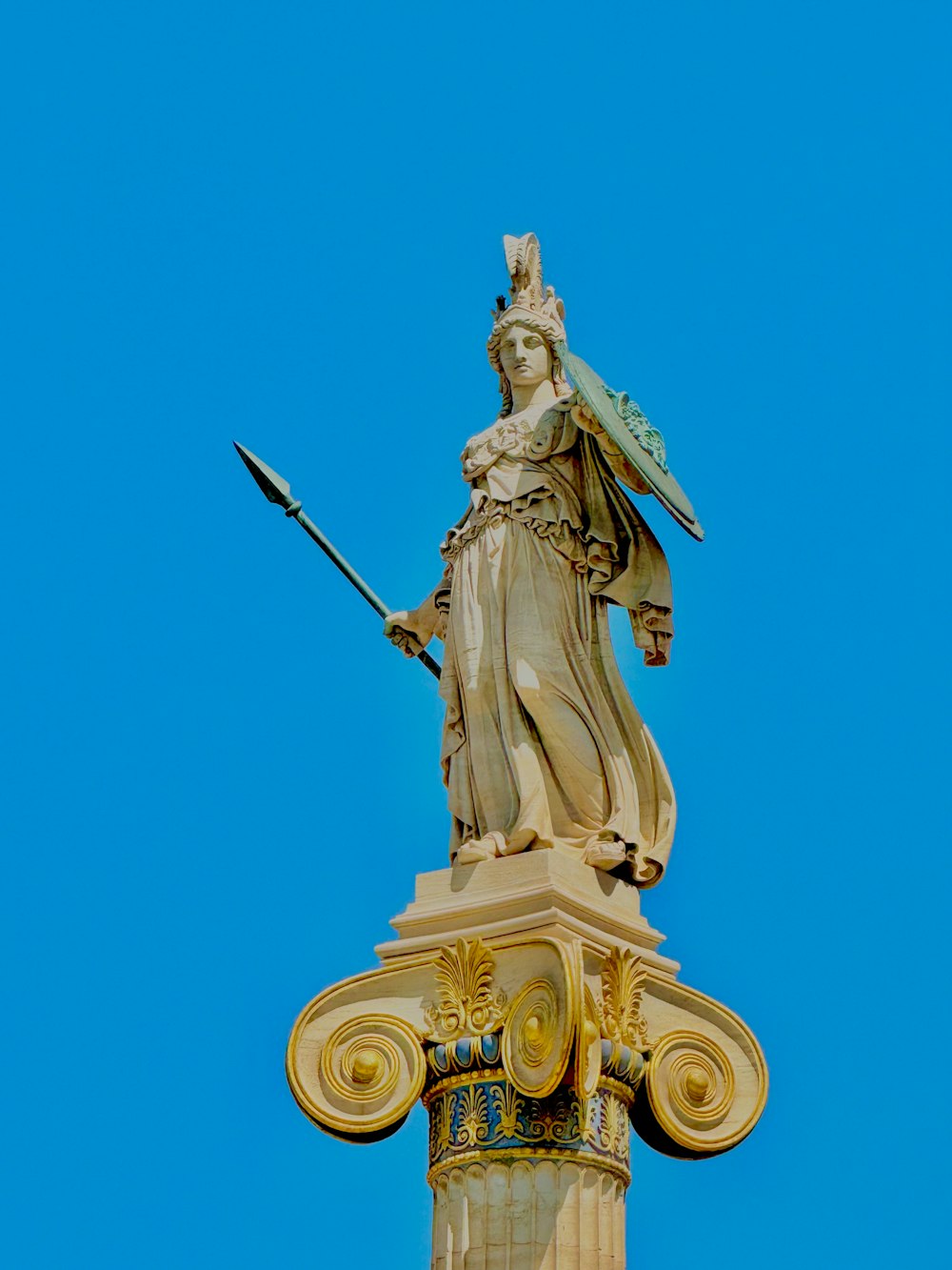 a statue of a woman holding a sword on top of a building