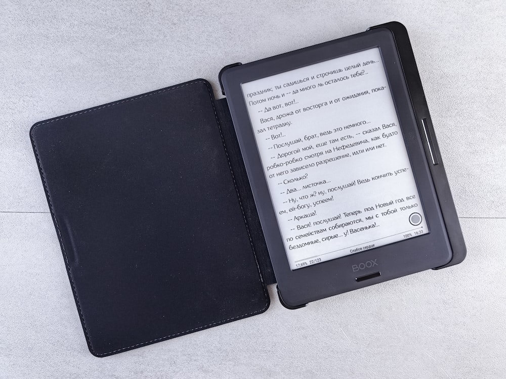 a kindle sitting on a table next to a book