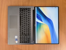 a laptop computer sitting on top of a wooden table