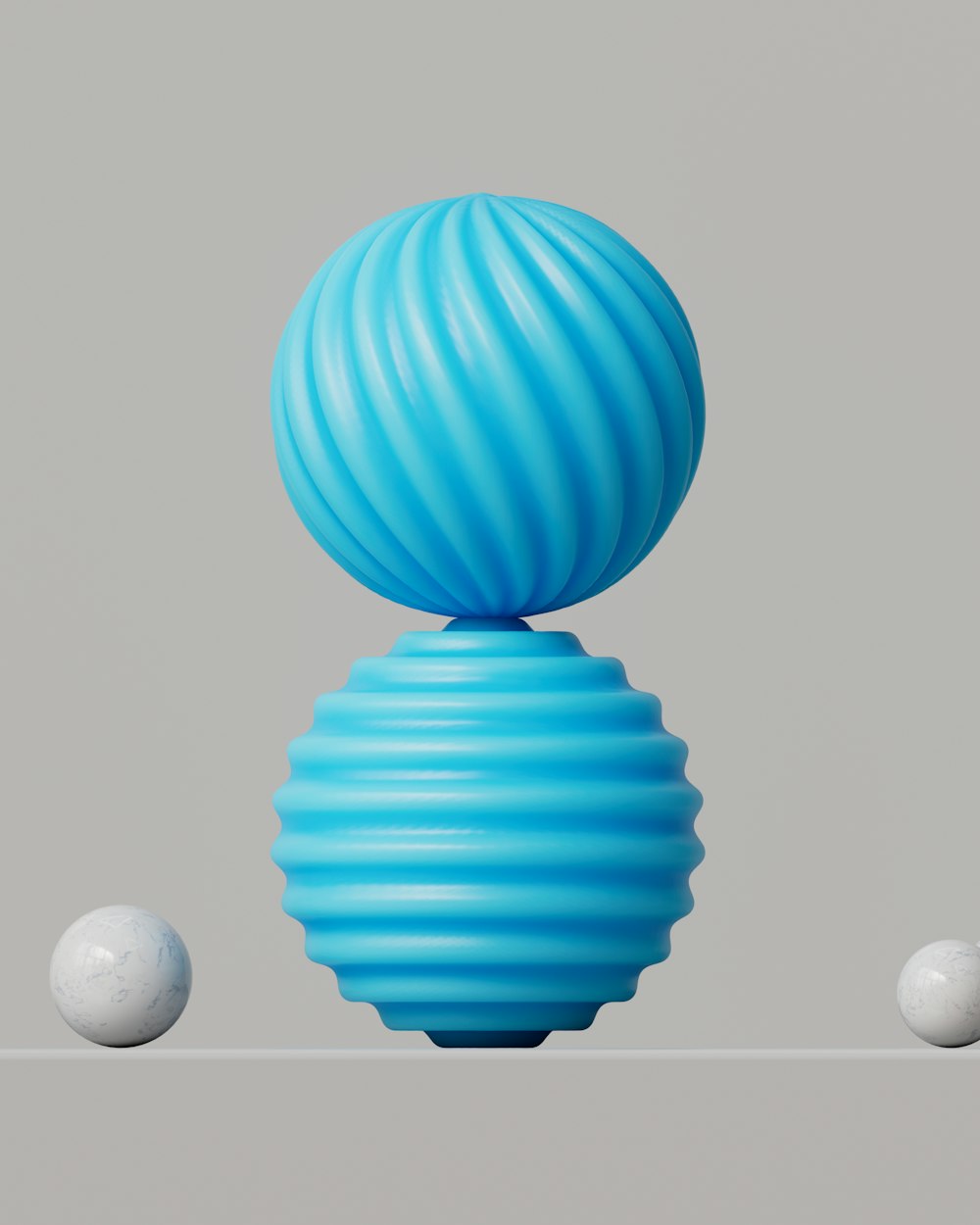 a blue vase sitting on top of a table next to three white balls