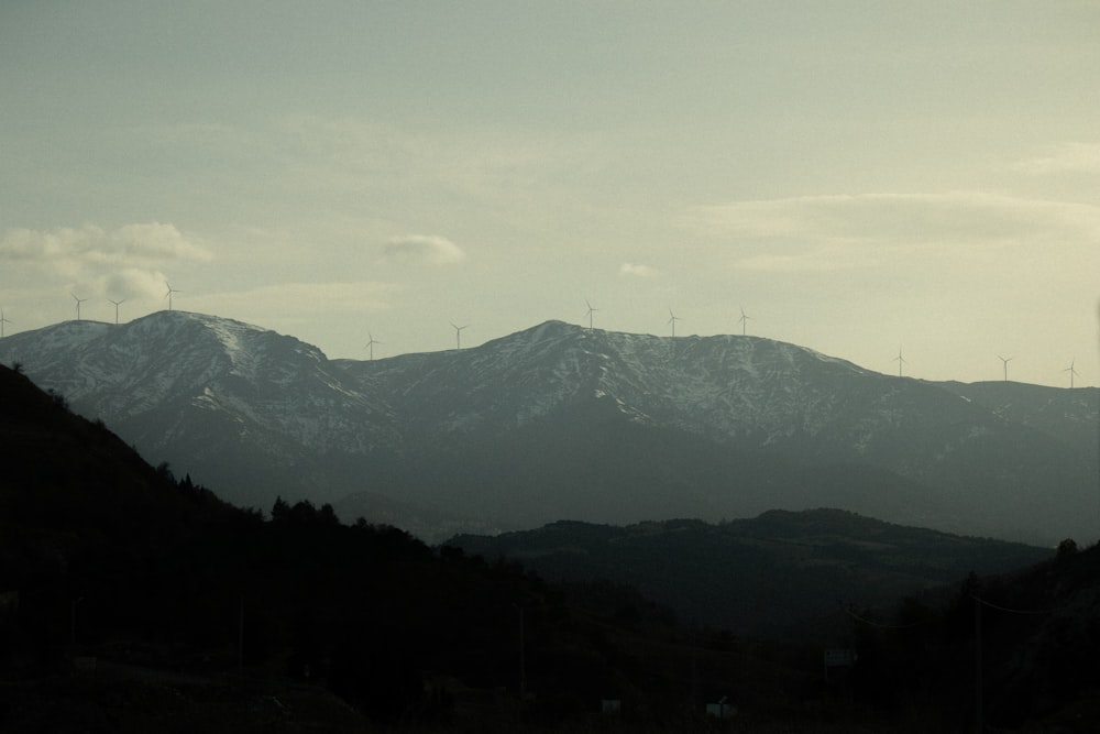 a view of a mountain range with wind mills in the distance