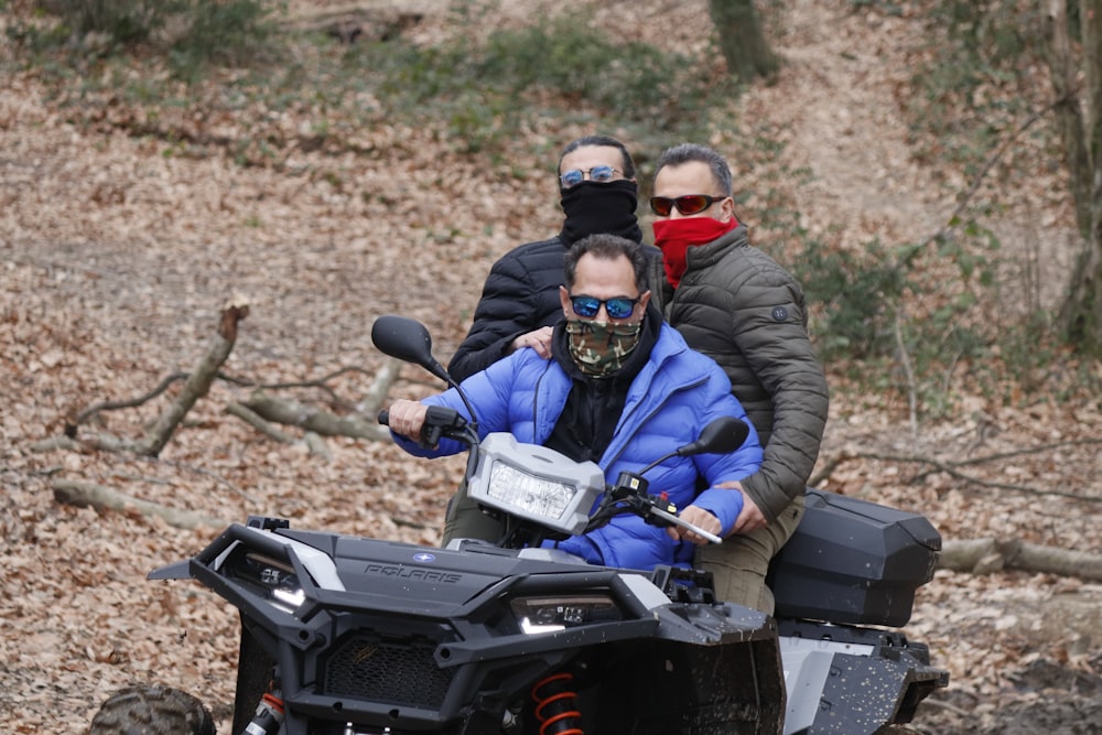 a group of people riding on the back of an atv