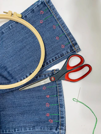 a pair of scissors sitting on top of a pair of jeans